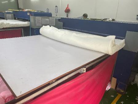 Fabric cutting area with a cutting table and a roll of shell fabric