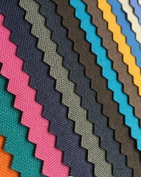 Strips of fabric swatches in several colours and weaves laid side by side